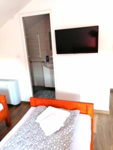 a small bedroom with a bed and a television at Vaš Kutak 2026 - Sobe Lux za izdavanje in Obrenovac
