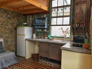 a kitchen with a white refrigerator and a sink at La Casita Azul in Caleta de Interián