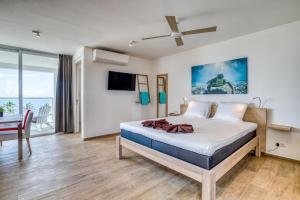 a bedroom with a bed and a dining room with a table at Chogogo Dive & Beach Resort Bonaire in Kralendijk