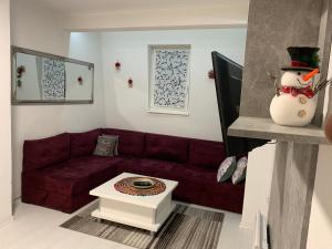 sala de estar con sofá rojo y muñeco de nieve en Apartmani Šišava apt "HARMONY" Vlašić en Vlasic