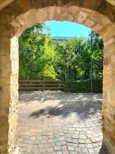 une arche dans une cour en briques avec une clôture dans l'établissement Alte Stadtmauer - Apartment, à Sinsheim