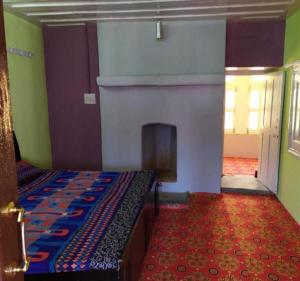 a room with a bed and a fireplace in it at Madhan Palace Homestay in Dharmpur