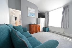 a living room with a blue couch and a window at Avoncot Guest House in Stratford-upon-Avon