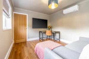 sala de estar con sofá y escritorio en Mrs Hortons Guest Rooms, en Sutterton