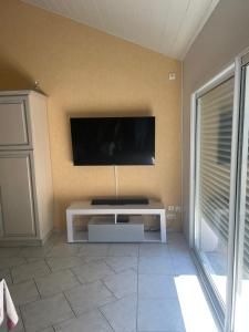 ein Wohnzimmer mit einem Flachbild-TV an der Wand in der Unterkunft La belle Vendéenne in La Tranche-sur-Mer