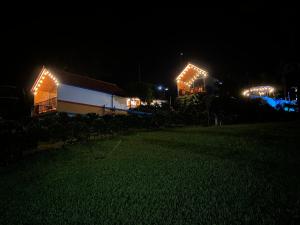 a couple of buildings with lights on them at night at Cabaña Filo de Oro, jardín in Jardin