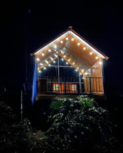 una casa con luces encendidas por la noche en Cabaña Filo de Oro, jardín en Jardín