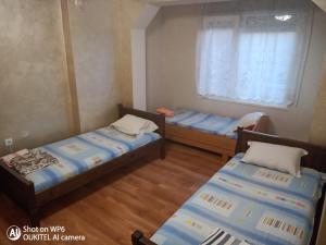 2 camas en una habitación pequeña con ventana en Guest House "Dimova" en Svilengrad