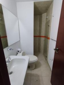 a bathroom with a toilet and a sink and a mirror at Hotel Arena Plaza Inn in Bogotá