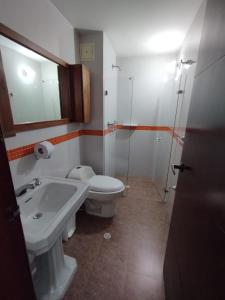 a bathroom with a sink and a toilet and a mirror at Hotel Arena Plaza Inn in Bogotá