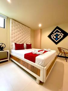 a bedroom with a large bed with red pillows at Hotel Plaza Garibaldi in Caldas