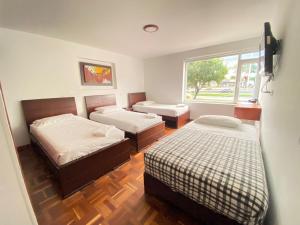 a bedroom with two beds and a window at Hotel Arena Plaza Inn in Bogotá