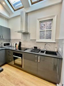 een keuken met een wastafel en een fornuis top oven bij Micklegate Apartment in York