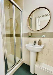 een badkamer met een wastafel en een spiegel bij Micklegate Apartment in York