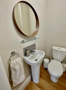 een badkamer met een toilet, een wastafel en een spiegel bij Micklegate Apartment in York