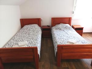 two twin beds in a room with wooden floors at Vaš Kutak - Sobe Lux za izdavanje in Obrenovac
