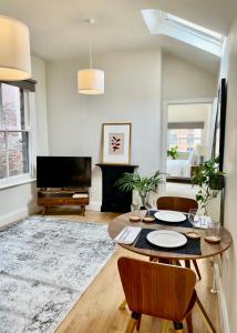 een woonkamer met een tafel, stoelen en een televisie bij Micklegate Apartment in York