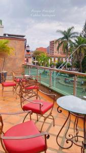 un grupo de sillas y mesas en un balcón en Hotel Plaza Garibaldi, en Caldas