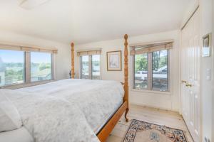 a bedroom with a large bed and windows at Hoopdee Scootee Suite in Saugatuck