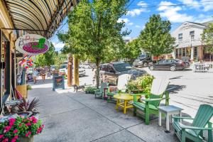 a sidewalk with chairs and tables on a city street at Hoopdee Scootee Suite in Saugatuck