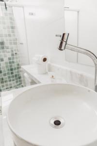 a white sink with a faucet on top of it at Garça Branca Praia Hotel in Porto Seguro