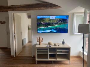 sala de estar con TV colgada en la pared en Charmant appartement avec SPA, en Fontenay-le-Comte