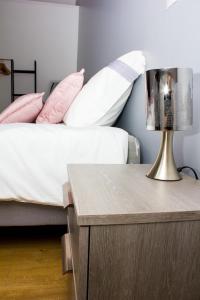 een slaapkamer met een bed en een tafel met een lamp bij F2 Duplex chez l'aventurière près Disneyland in Roissy-en-Brie