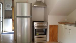 a kitchen with a stainless steel refrigerator and a stove at Stuarts Cottage in Wanaka