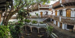 Vue de tête d'un bâtiment avec un arbre dans l'établissement Hotel los Arcos, à Taxco