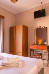 1 dormitorio con 1 cama y escritorio con TV en Apagio Apartments en Mikros Gialos