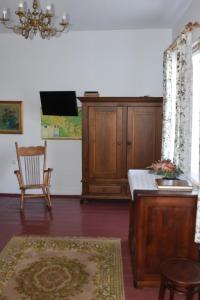 a living room with a tv and a chair at Dom pod Platanami in Bondyrz +1 photo