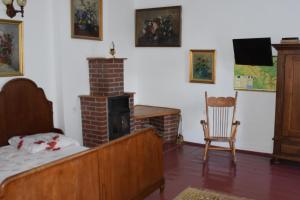 a bedroom with a bed and a brick fireplace at Dom pod Platanami in Bondyrz