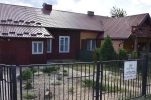 a house with a fence in front of it at Dom pod Platanami in Bondyrz
