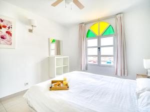 a white bedroom with a white bed with a tray on it at Marina nº 5 in Puerto de Mogán