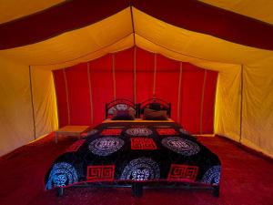 Bivouac Les Nomades & Foum zguid to chegaga tours في Foum Zguid: غرفة نوم بسرير في خيمة