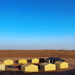 a group of tents in the middle of a desert at Bivouac Les Nomades & Foum zguid to chegaga tours in Foum Zguid