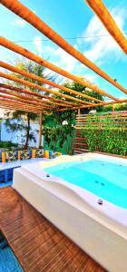 un patio con bañera de hidromasaje y terraza de madera en Di Pipa Rooms - Hidromassagem Externa, en Pipa