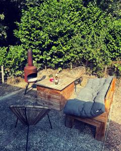 een bank, een tafel, een stoel en een fornuis bij Heerlijk bos chalet met ongekende rust en vrijheid in Nunspeet