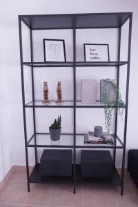 a black shelving unit with two shelves at 4 Elements Apartment in Peniche