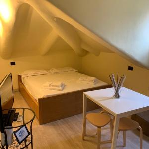 トリノにあるMansarda Barettiのベッドとテーブル付きの小さな部屋