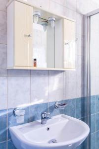 W łazience znajduje się biała umywalka i lustro. w obiekcie Apagio Apartments w mieście Mikros Gialos