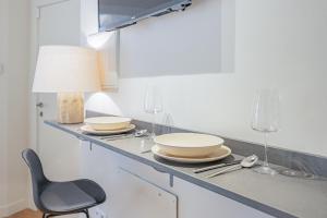 blat kuchenny z talerzami, okularami i krzesłem w obiekcie Apartment in the Heart of the Historic Center w Maladze