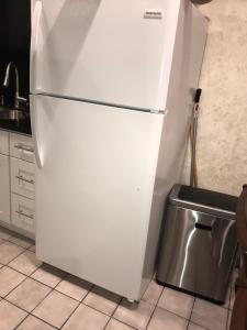 a white refrigerator in a kitchen with a trash can at Beautiful 1BD apartment in Los Angeles