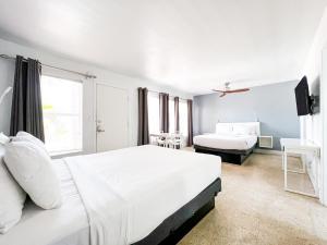 a white bedroom with two beds and a window at Winterset in Fort Lauderdale