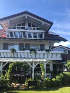 Casa blanca grande con balcón blanco en Ferienwohnung Lisi Hartmann, en Blaichach