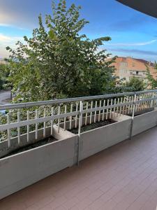 a white fence next to a tree on a sidewalk at A casa di Frida & Mika - COMODO PUNTO DI SOSTA - Vicino a tutti i servizi - a 20 minuti dall'autostrada in Civita Castellana
