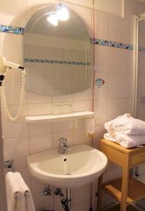 a bathroom with a sink and a mirror at Kurhotel Schlossberghof Marzoll in Bad Reichenhall