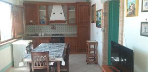 a kitchen with a table and chairs and a sink at Villa dei Focesi in Ascea