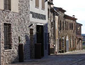 a stone building with a sign on the side of it at Hotel MedinaSalim in Medinaceli