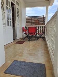 eine Terrasse mit 2 Stühlen und einem Tisch auf der Veranda in der Unterkunft LES 4L Caïmite in Le Carbet